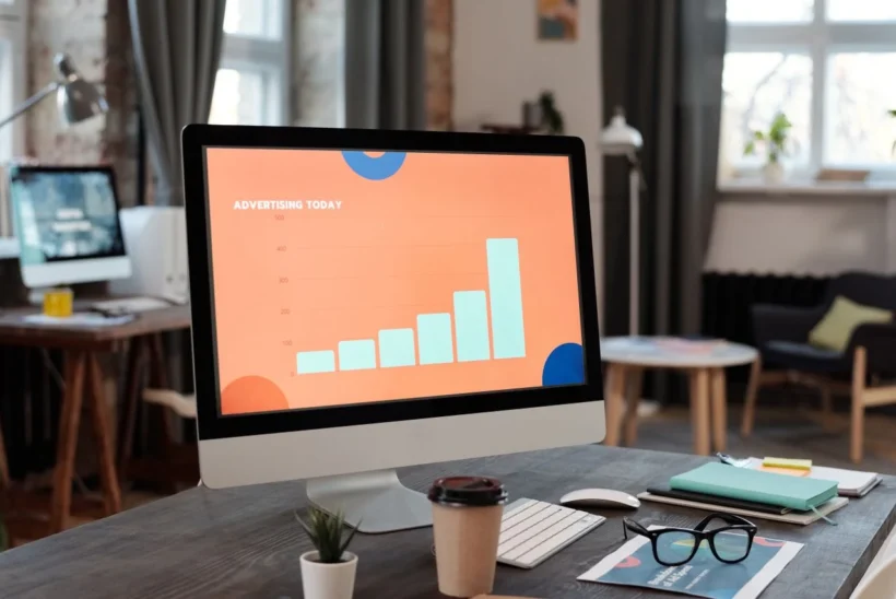 Computador em escritório exibindo gráficos de performance em marketing digital, sugerindo monitoramento e métricas para Agência de tráfego pago em Curitiba: quando e quais métricas cobrar